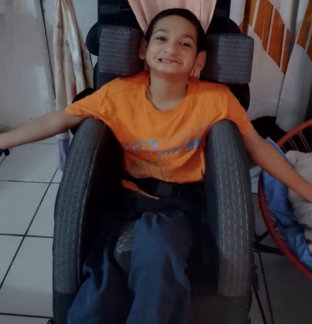 Niño de la comunidad utilizando una silla con soporte de posicionamiento